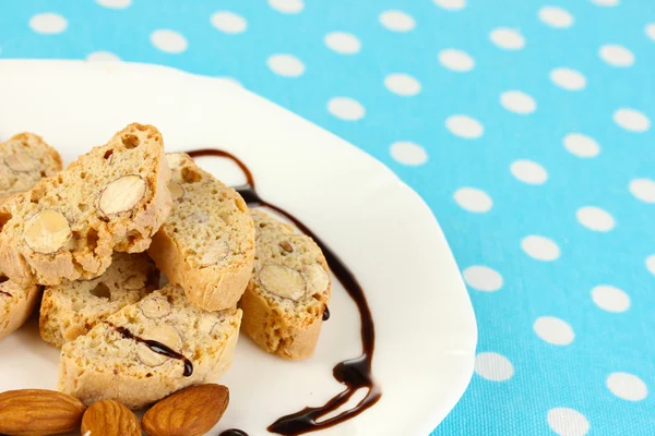 Galletas aromáticas cantuccini en placa sobre mantel azul primer plano —  Fotos de Stock