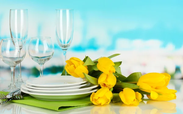 Gele tulpen en gebruiksvoorwerpen voor portie op blauwe natuurlijke achtergrond achtergrond — Stockfoto