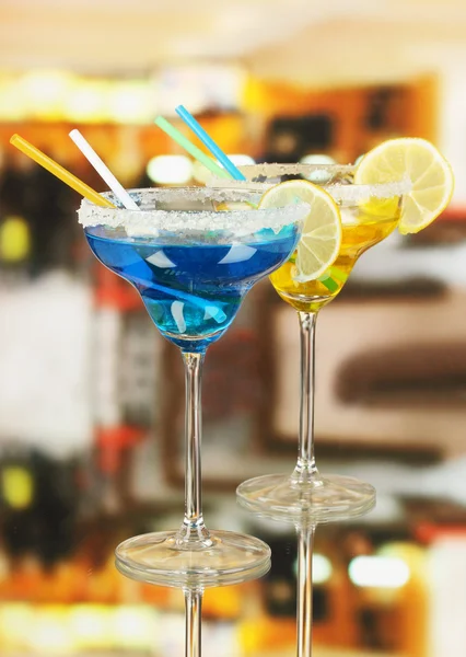 Yellow and blue cocktails in glasses on room background — Stock Photo, Image