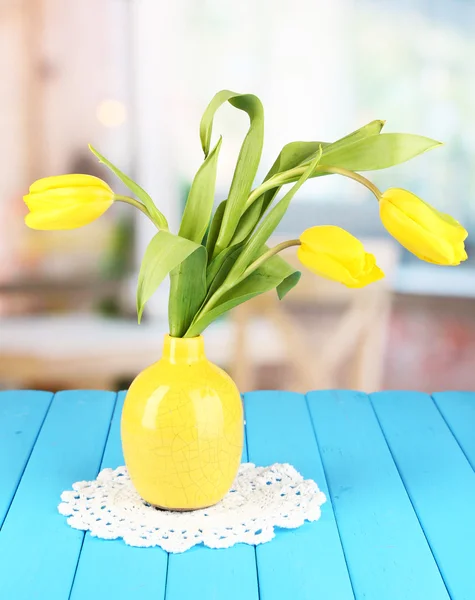 Oda arka plan üzerinde ahşap masa üzerinde vazoda Sarı laleler — Stok fotoğraf