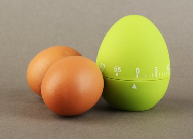 Yeşil yumurta zamanlayıcı ve renkli arka plan üzerinde yumurta