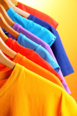 t-shirt bir sürü askıları turuncu zemin üzerinde