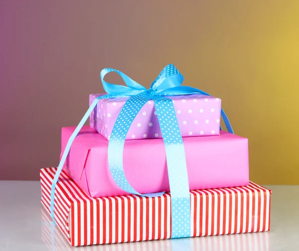 Συσκευασία δώρου που δένεται ψηλά με κορδέλα σε φόντο χρώμα — Φωτογραφία Αρχείου