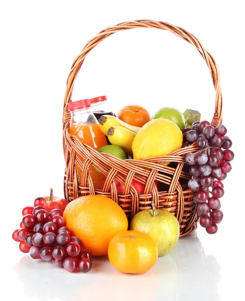 Diferentes frutas en canasta de mimbre con jugo aislado en blanco — Foto de Stock