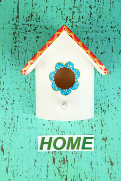 Decorative nesting box and sign on color background — Stock Photo, Image