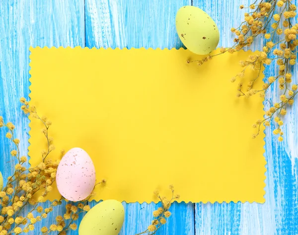 Leere Karte mit Ostereiern und Mimosen, auf blauem Holzgrund — Stockfoto