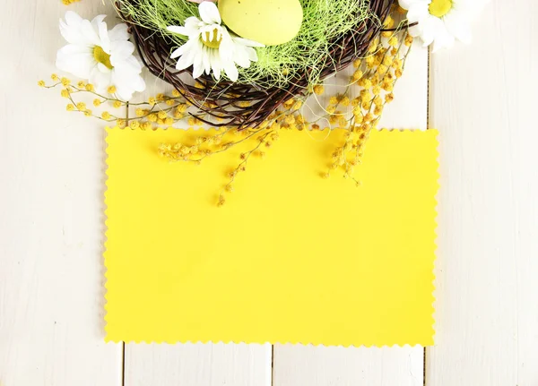 Prázdná karta s velikonoční vajíčka a mimózy květů na bílém pozadí dřevěná — Stock fotografie