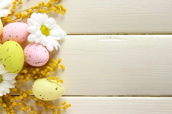 Huevos de Pascua y flores de mimosa, sobre fondo de madera blanca —  Fotos de Stock