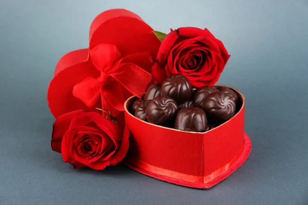 Doces de chocolate em caixa de presente, em fundo cinza — Fotografia de Stock