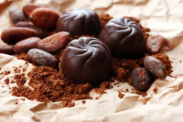 チョコレートのお菓子と茶色の背景にココアの組成 — ストック写真
