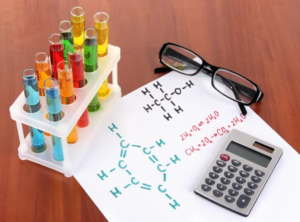 Probówki z kolorowych płynów i formuły w tabeli — Zdjęcie stockowe