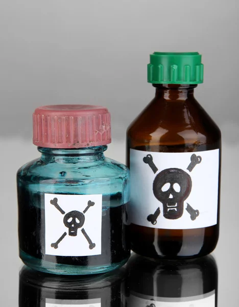 Poison mortel dans des bouteilles sur fond gris — Photo