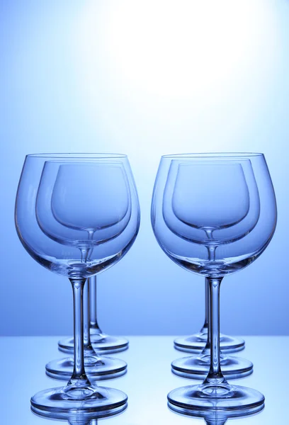 Порожні келихи для вина, розташовані на синьому фоні — стокове фото