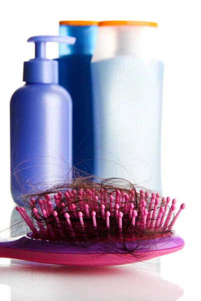 Comb brush with lost hair and cosmetics bottles, isolated on white — Stock Photo, Image