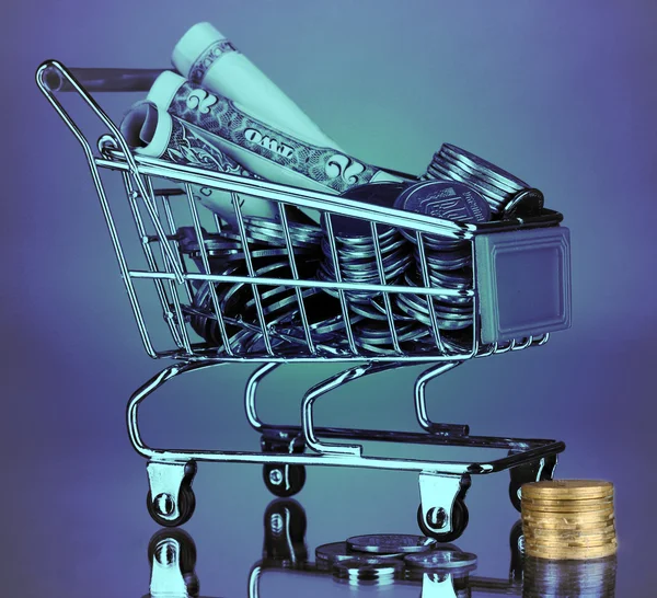 Money in cart in blue light — Stock Photo, Image