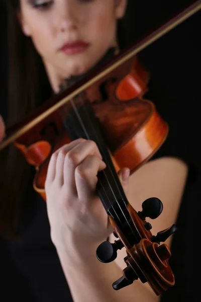 Музыкант играет на черном фоне на скрипке — стоковое фото