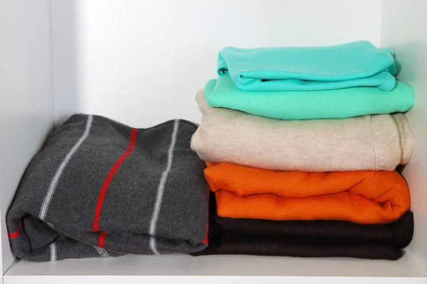 Clothes neatly folded on shelves — Stock Photo, Image