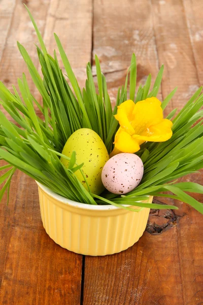Huevos de Pascua en tazón con hierba sobre mesa de madera de cerca — Foto de Stock