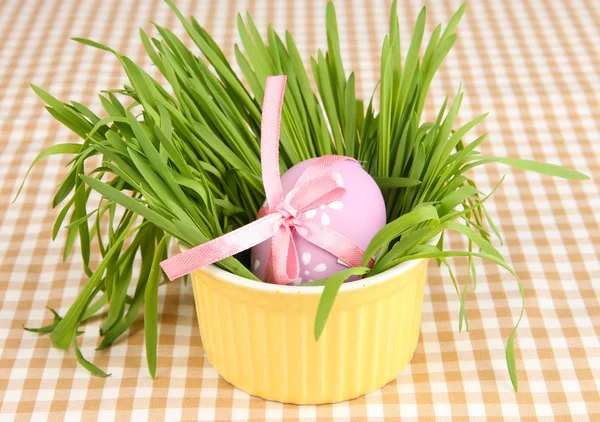 Osterei in Schüssel mit Gras auf dem Tisch in Großaufnahme — Stockfoto