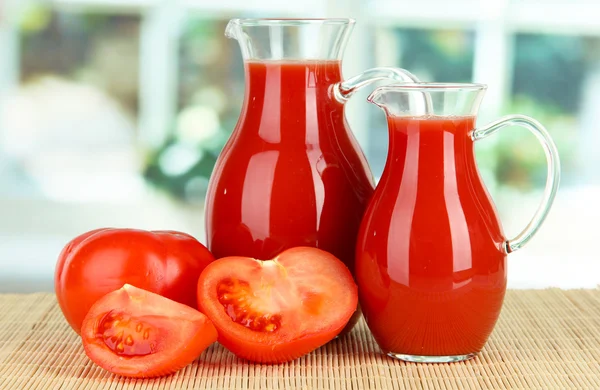Tomato juice in pitchers on table in room — Stock Photo, Image