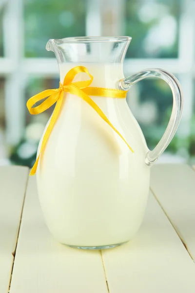 Pitcher of milk on table in room — Stock Photo, Image