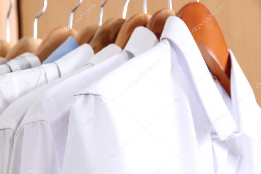 Men's shirts on hangers in wardrobe — Stock Photo © belchonock #22706283