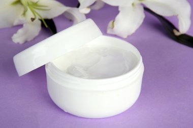 kozmetik krem ve mor zemin üzerine güzel zambak