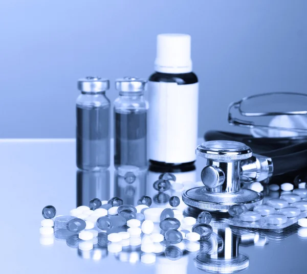 Gyógyszerek és sztetoszkóp, kék fény — Stock Fotó