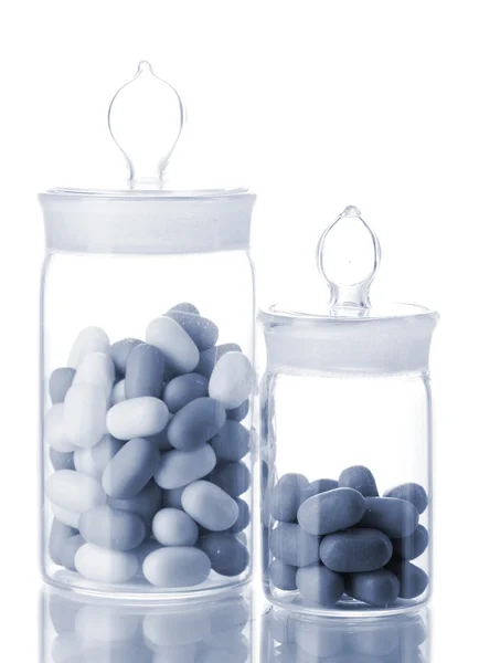 Frascos transparentes con pastillas en gris claro aislado sobre blanco —  Fotos de Stock
