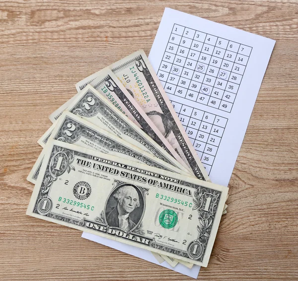 Lottery tickets with pen and money, on wooden background — Stock Photo, Image