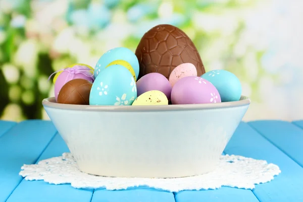 Состав пасхальных и шоколадных яиц на деревянном столе на естественном фоне — стоковое фото