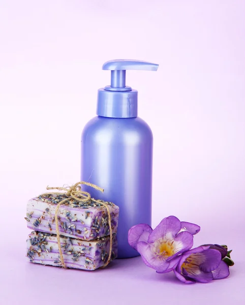 Жидкое и ручное мыло на фиолетовом фоне — стоковое фото