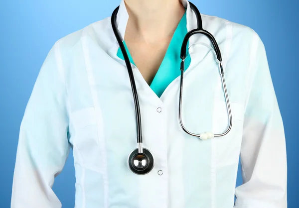 Medical doctor with stethoscope, on color background — Stock Photo, Image