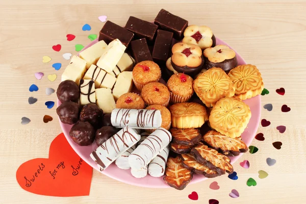 Dolci biscotti con cartolina di San Valentino su piatto su fondo di legno — Foto Stock