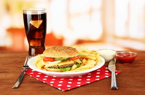 Gustoso cheeseburger con patate fritte e bevanda fredda, su sfondo brillante — Foto Stock