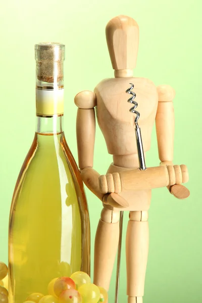 Mannequin avec tire-bouchon et bouteille de vin, sur fond vert — Photo