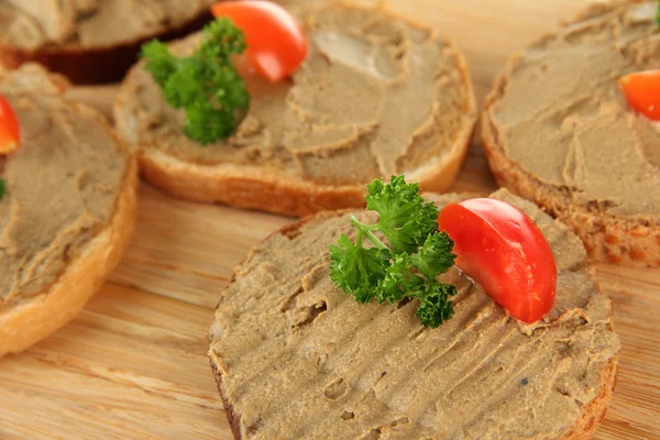 Fresh pate on bread on wooden board, close up — Stock Photo, Image