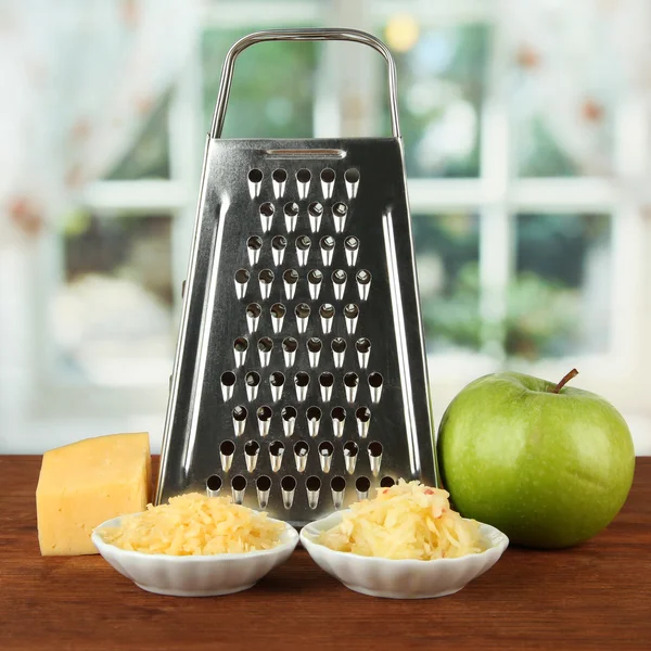 Metal grater and cheese, apple on bright background — Stock Photo, Image