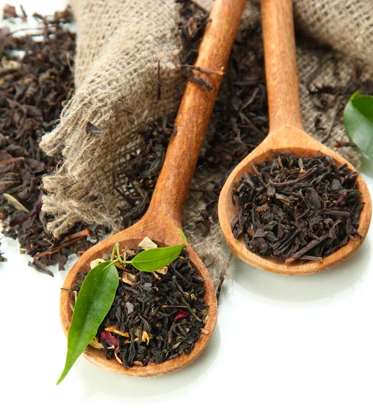 Té seco con hojas verdes en cucharas de madera, aislado sobre blanco —  Fotos de Stock