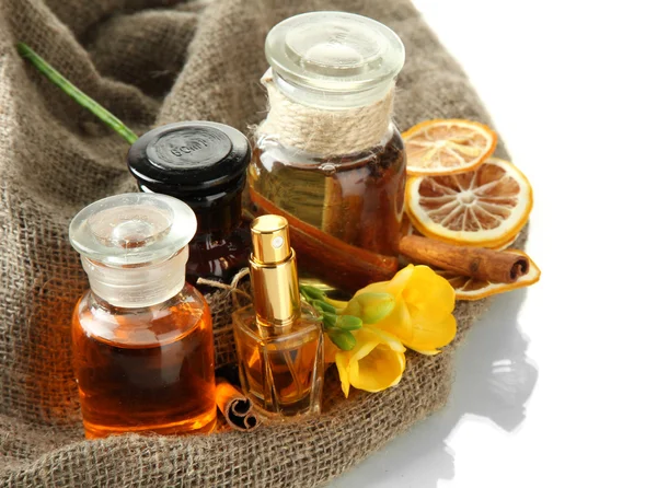 Botellas con ingredientes para el perfume en arpillera, aisladas en blanco —  Fotos de Stock
