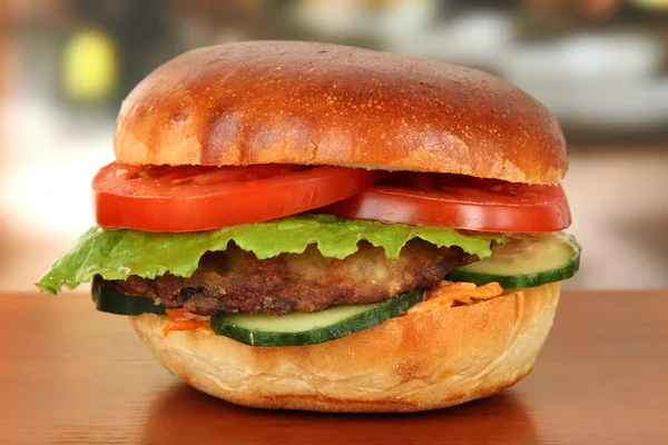 Grote en smakelijke hamburger op tafel in café — Stockfoto