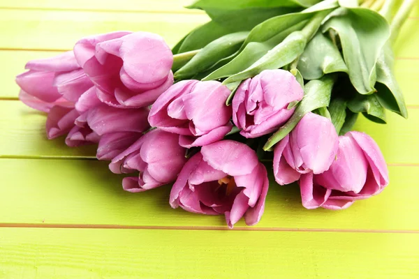 Belo buquê de tulipas roxas no fundo de madeira verde — Fotografia de Stock