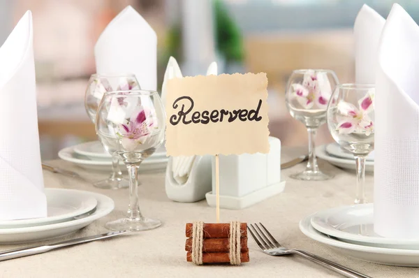 Letrero reservado en la mesa del restaurante con platos y vasos vacíos — Foto de Stock