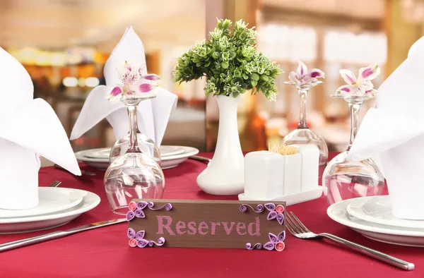 Panneau réservé sur la table du restaurant avec des plats vides et des verres — Photo