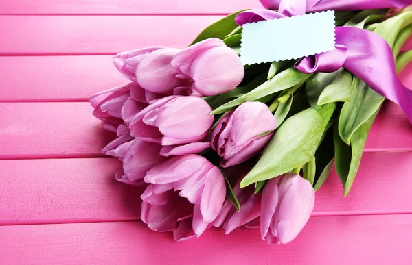 Piękny bukiet tulipanów fioletowy na różowym tle drewniane — Zdjęcie stockowe