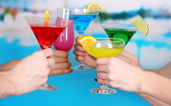 Cocktails i händerna på pool bakgrund — Stockfoto