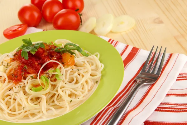 Sabroso espagueti con salsa y verduras en el plato en la mesa de madera de cerca —  Fotos de Stock