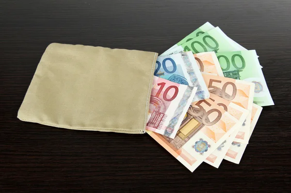 Bag of money with different euro banknotes on wooden background — Stock Photo, Image