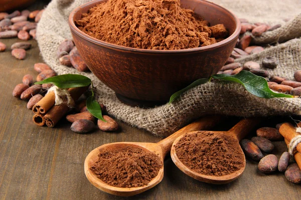 Poudre de cacao et fèves de cacao sur fond en bois — Photo