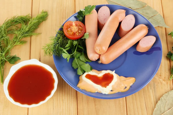 Saucisse, légumes verts, tomate sur table en bois — Photo